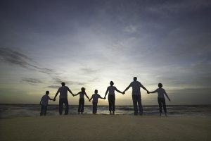 Magkahawak kamay ang pamilya sa dalampasigan