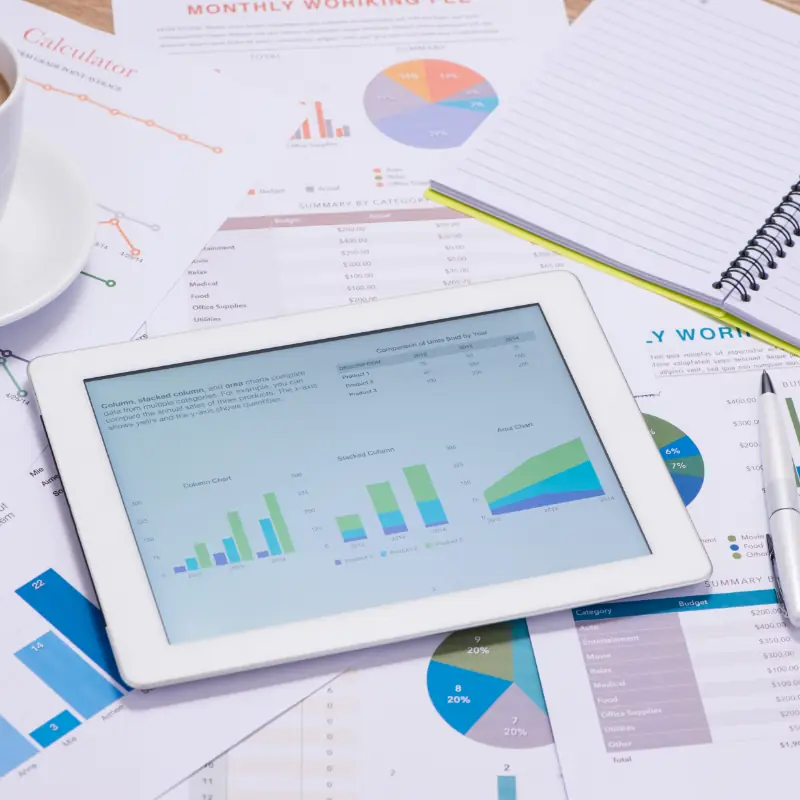 Stack ng mga graph ng negosyo na may iPad sa itaas